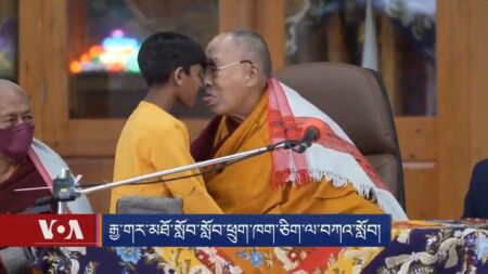 Dalai Lama mostra la lingua ad un bambino