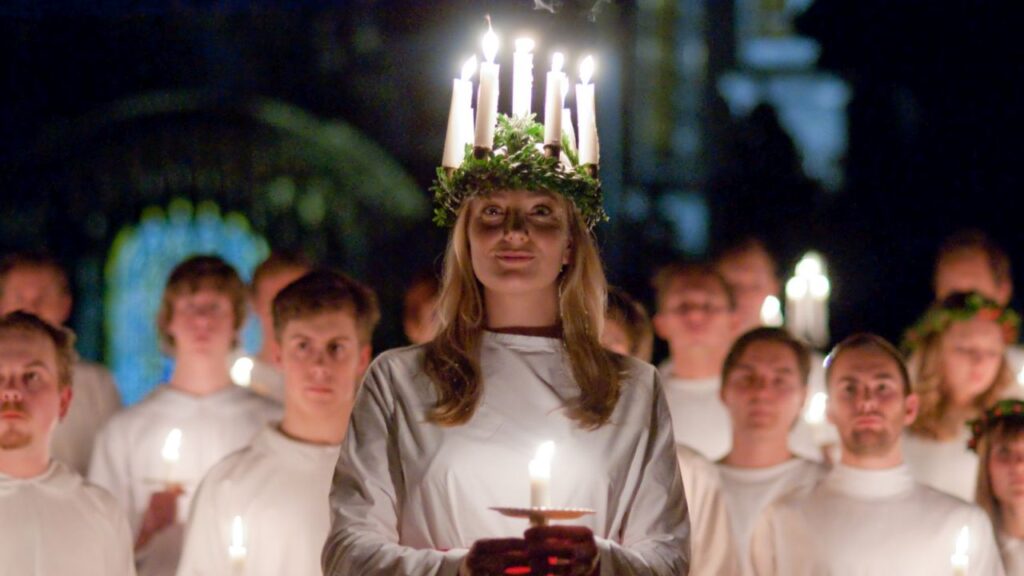 Una ragazza scandinava con la corona di candele in testa per Santa Lucia