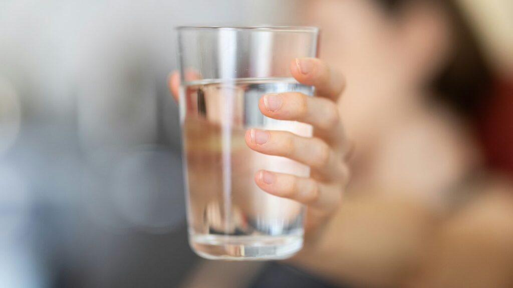 Una donna afferra un bicchiere d'acqua