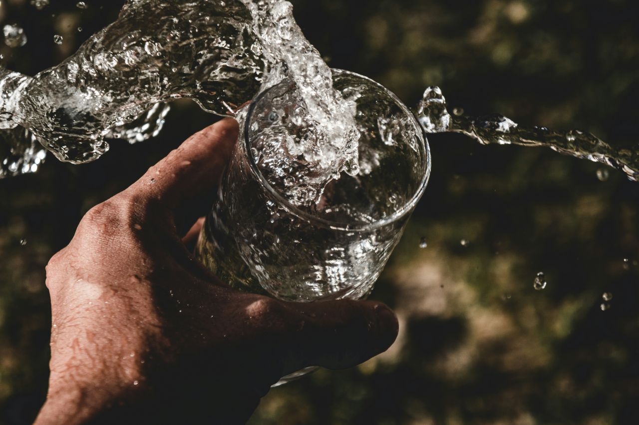 Uomo afferra bicchiere d'acqua