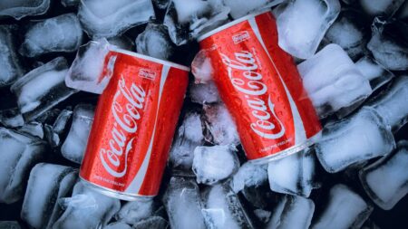 Due lattine di coca cola sul ghiaccio