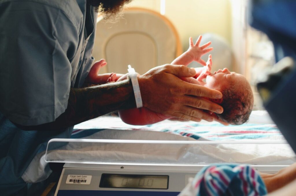 Un neonato tra le braccia di un infermiere