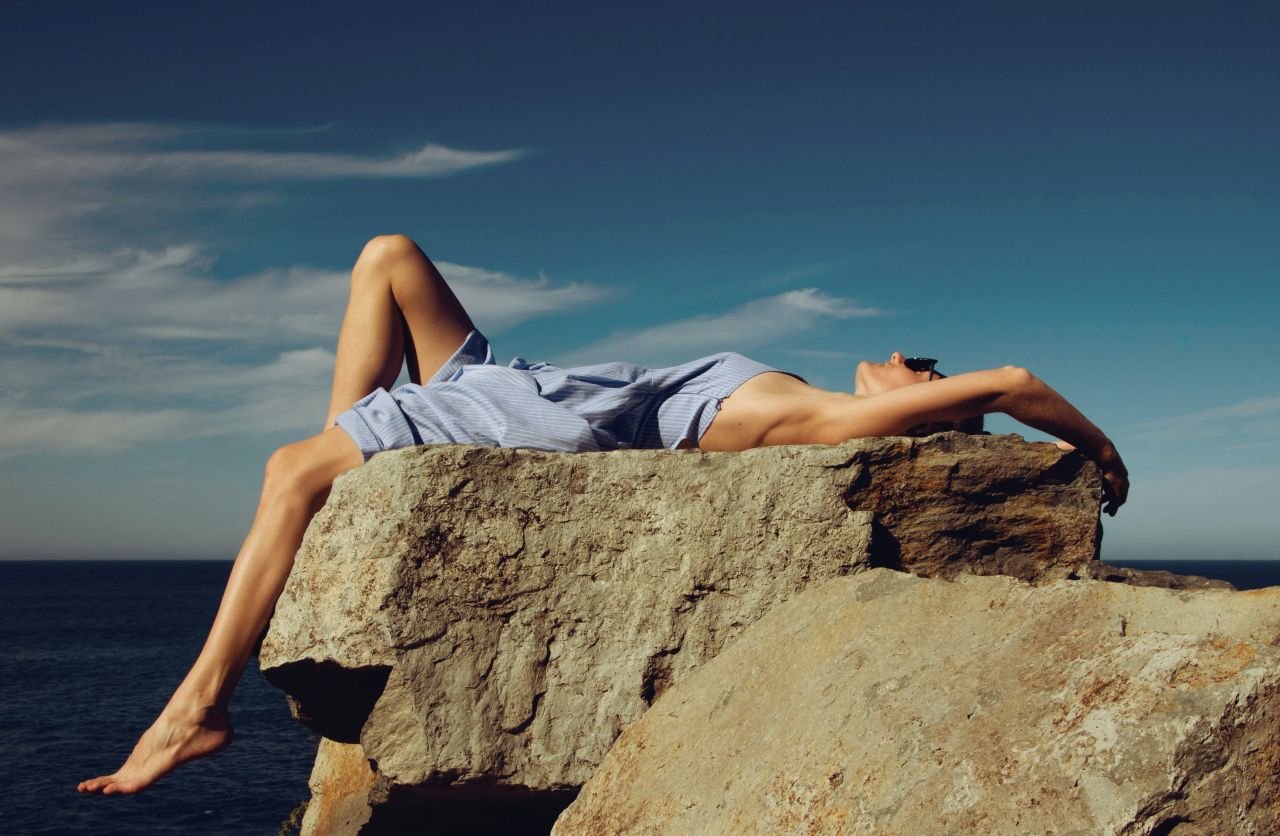 ragazza prende il sole su uno scoglio