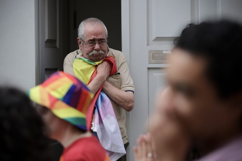 Uomo che abbraccia bandiera arcobaleno