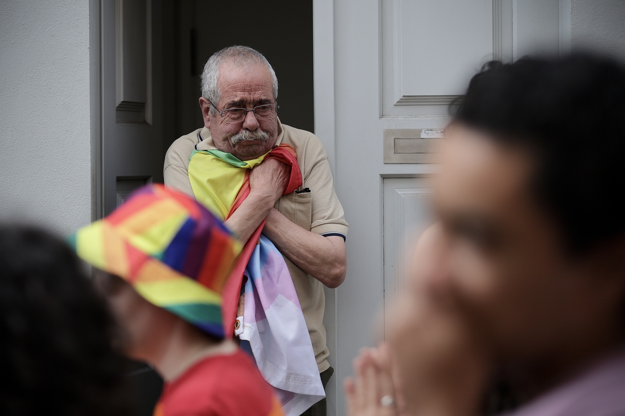 La foto dell’uomo che abbraccia la bandiera arcobaleno al Pride di Porto ha una storia incredibile