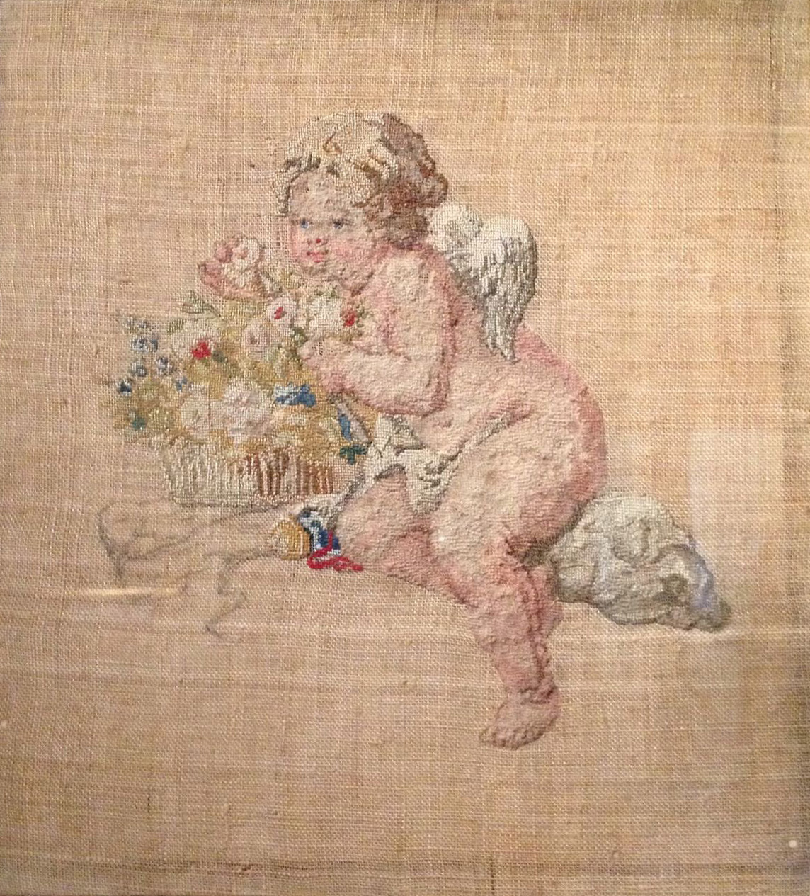 Ultimo ricamo di Maria Antoniettas che raffigura un putto biondo ed una cesta di fiori. 