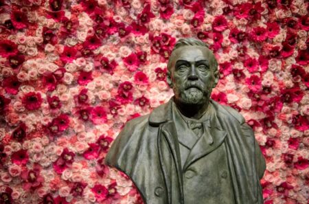 Busto di Alfred Nobel davanti a una composizione floreale