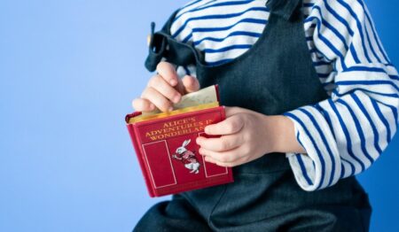 Bambina afferra il libro Alice nel paese delle meraviglie