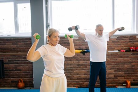 due adulti che fanno ginnastica coi pesi