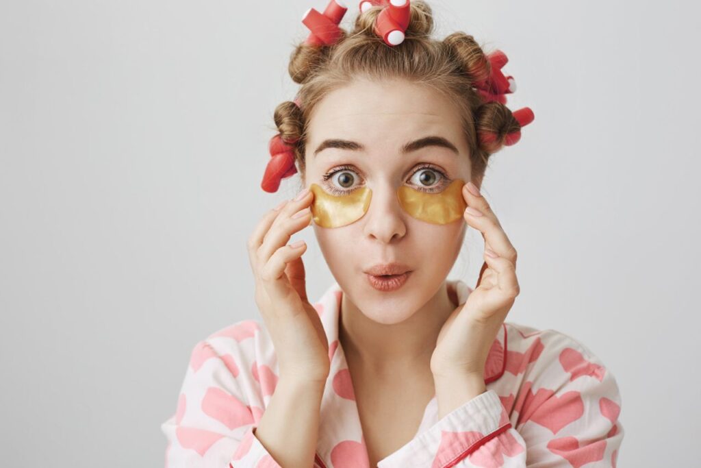 ragazza con bigodini in testa e patch occhi