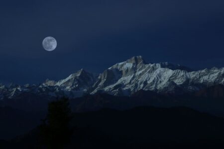 Luna piena su montagne innevate