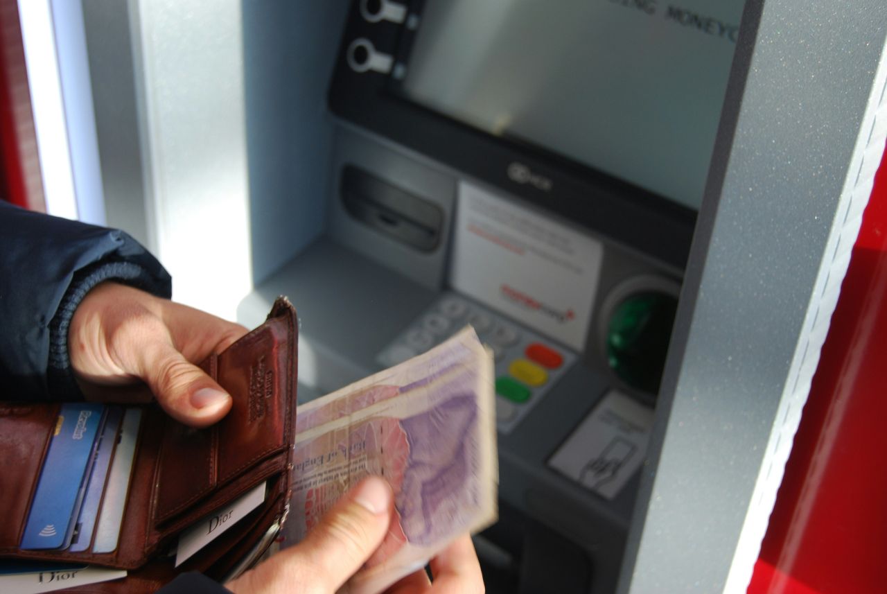 persona preleva soldi al bancomat