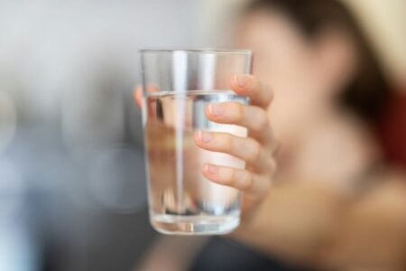 ragazza mostra bicchiere d'acqua