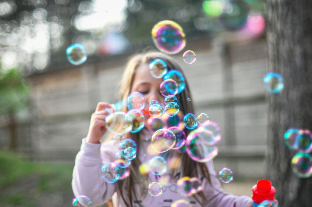 una bimba soffia sulle bolle di sapone