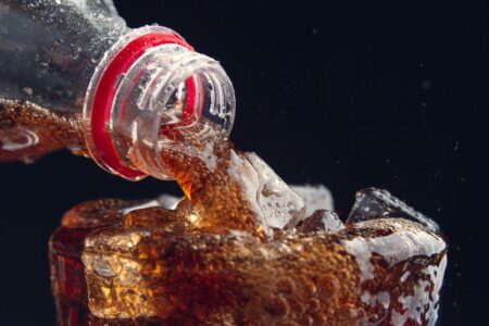 Coca Cola versata in un bicchiere ghiacciato