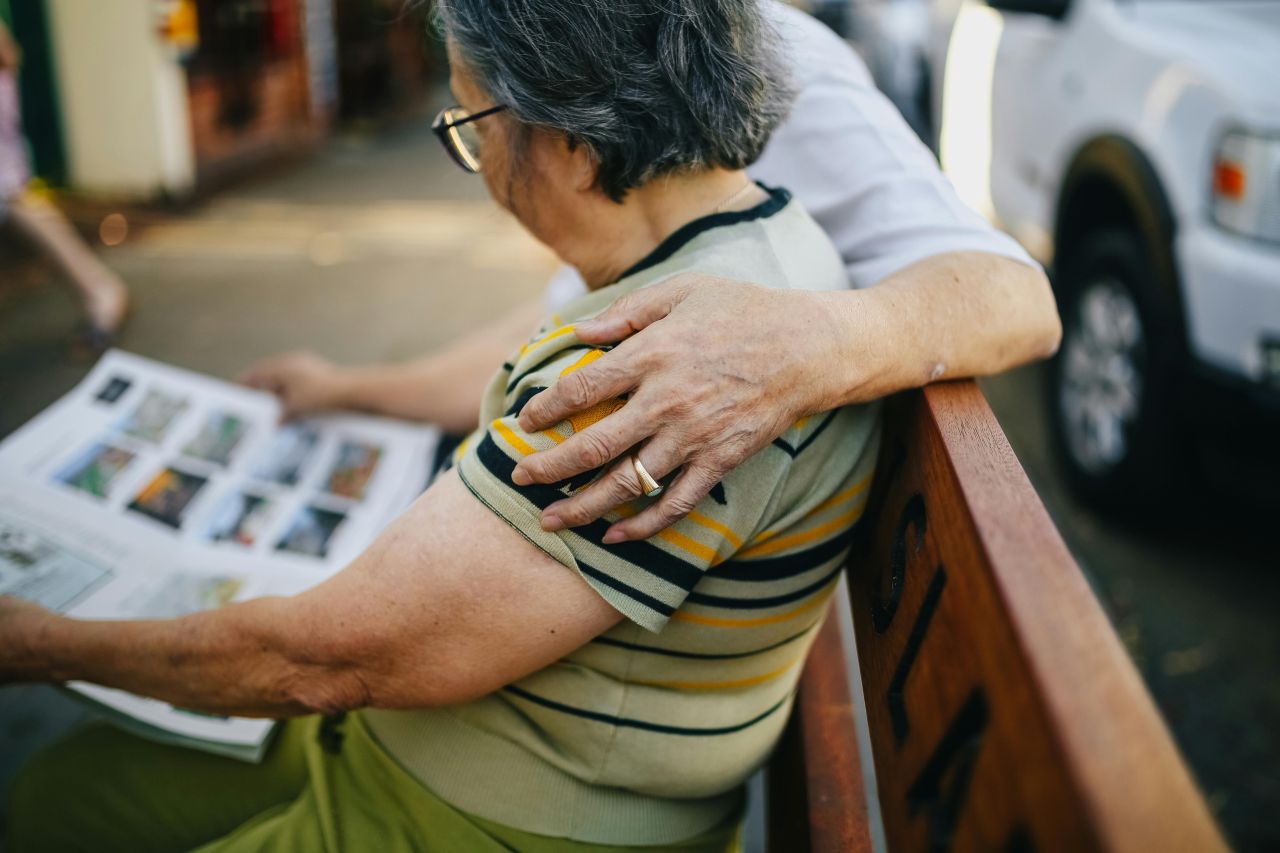 persone anziane si abbracciano sulla panchina