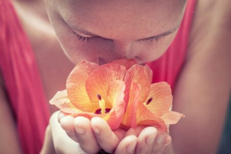 ragazza annusa un fiore