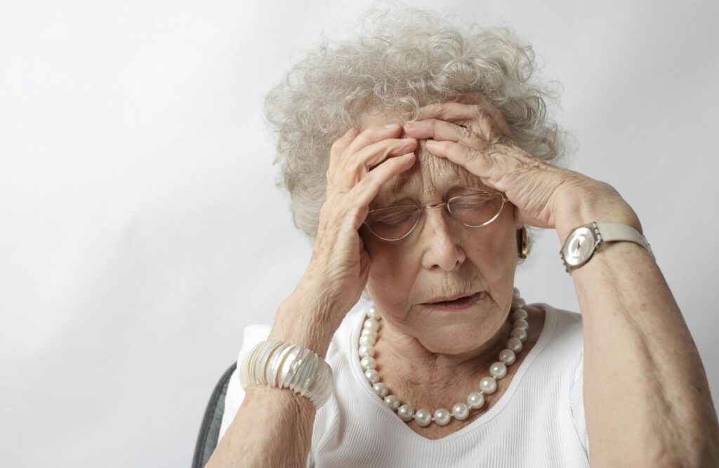 signora anziana si tocca la testa