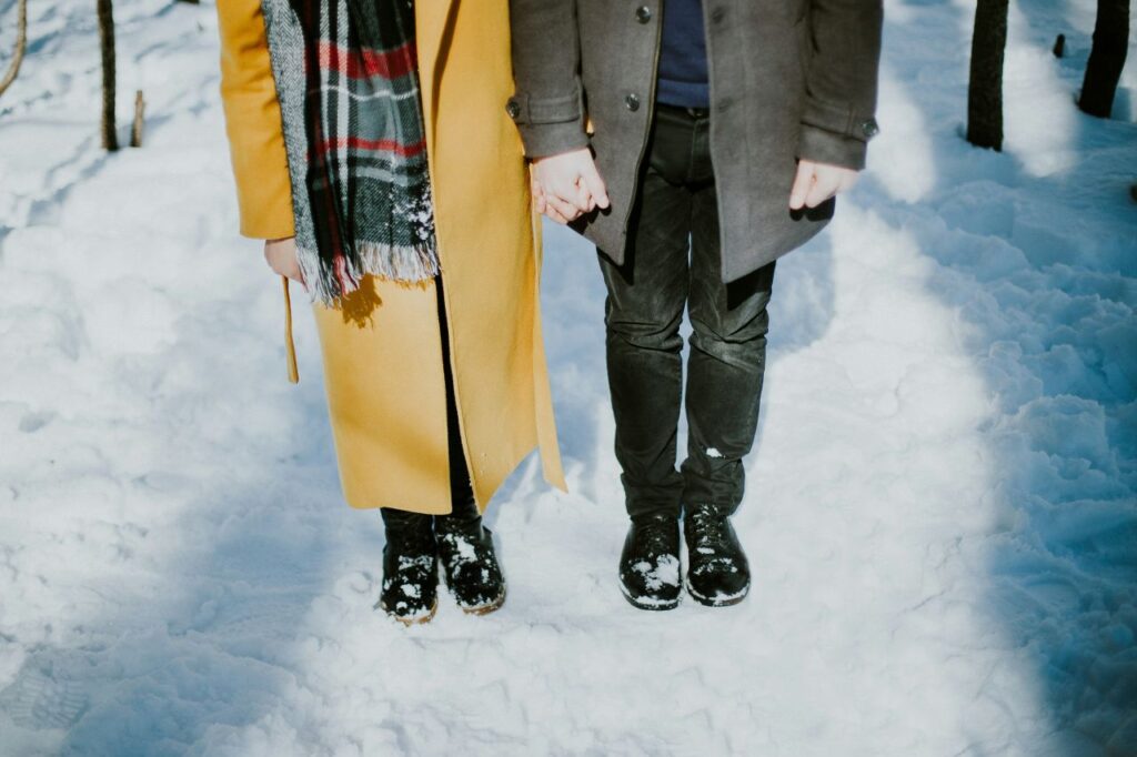 coppia mano nella mano nella neve