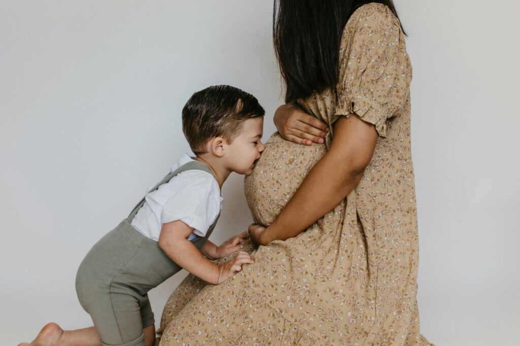 bambino bacia il pancione della sua mamma