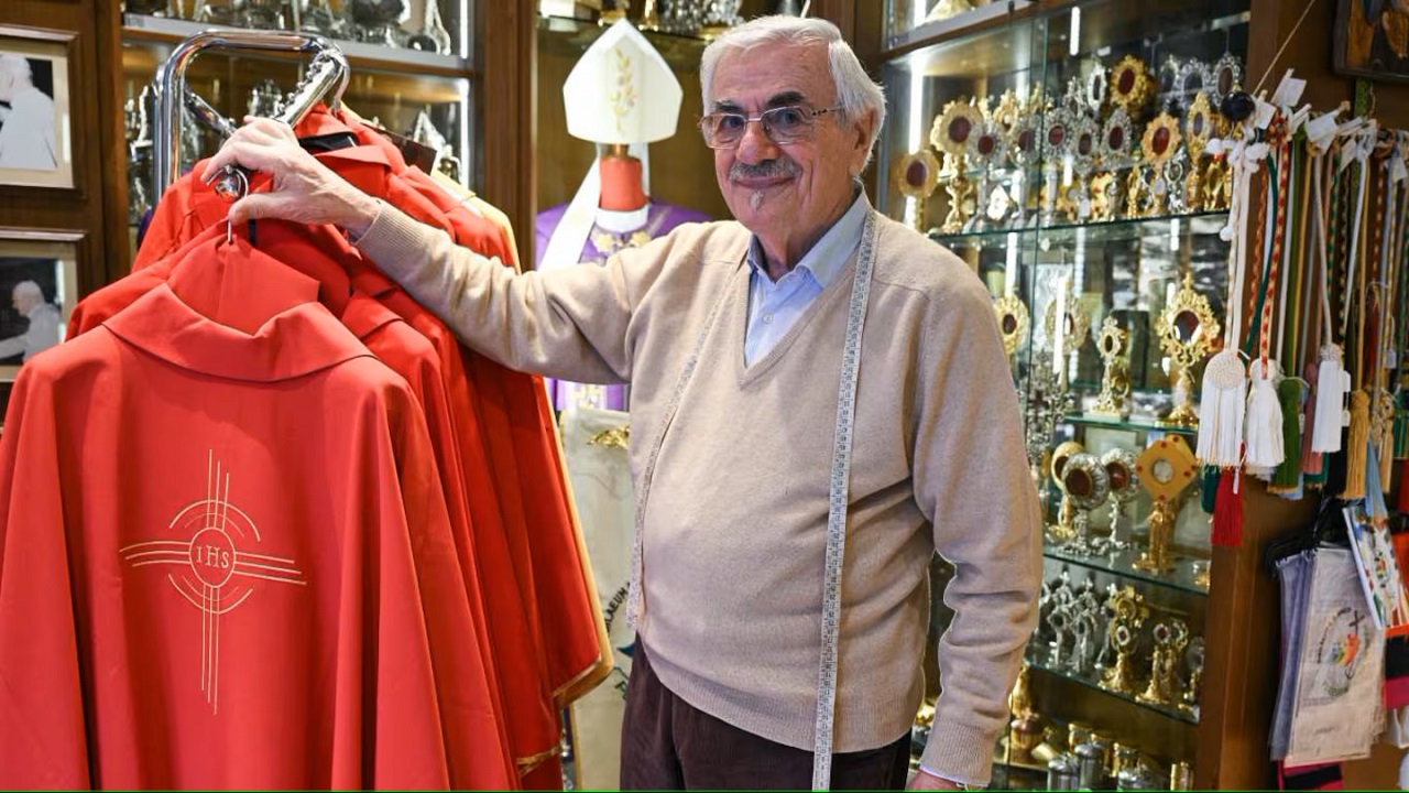 Raniero Mancinelli nel suo atelier, con alcuni abiti talari realizzati per il Vaticano