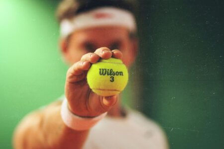 uomo che stringe pallina da tennis