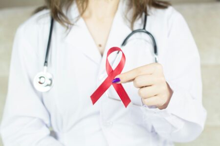 dottoressa mostra simbolo della lotta all'AIDS