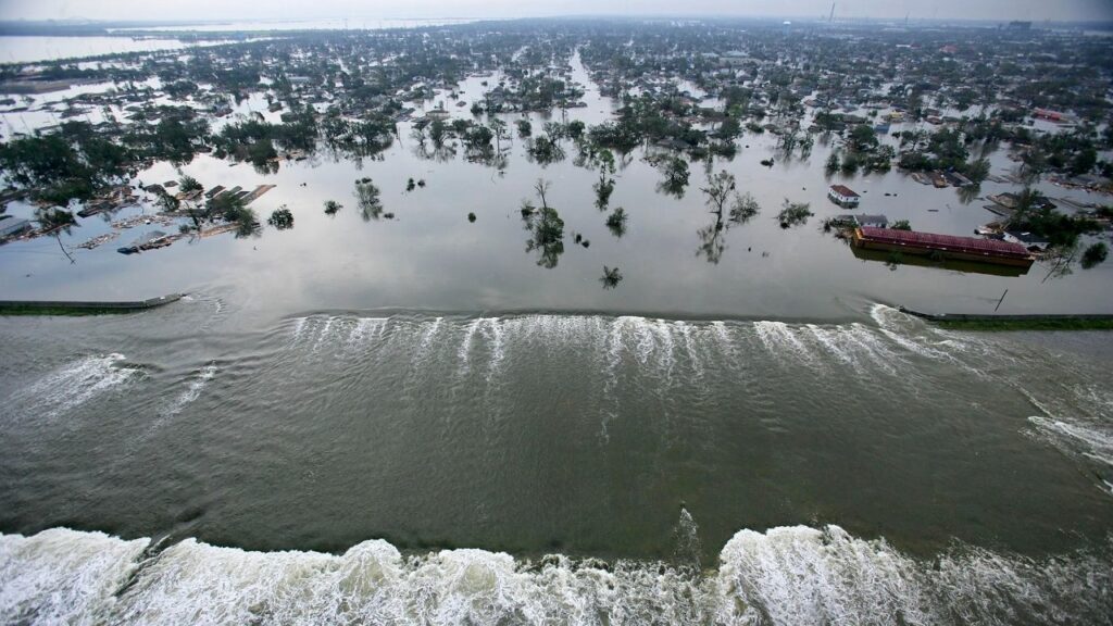 L'acqua rompe gli argini artificiali e si riversa su New Orleans durante l'uragano Katrina