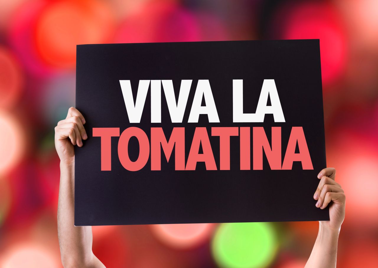 Persona sorregge cartello inneggianta alla Tomatina