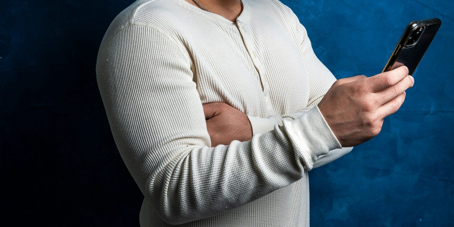 Il piacere proibito di guardare: quando il voyeurismo è gioco e quando diventa buio uomo che guarda il cellulare