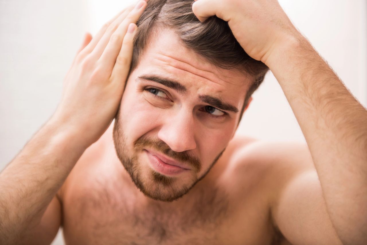 uomo controlla capelli