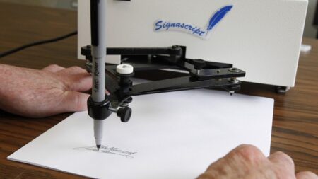 Dalla penna di Jefferson al braccio robotico: l’incredibile storia dell’Autopen e il suo ruolo nella politica americana Un modello di Autopen produce una firma su un foglio di carta