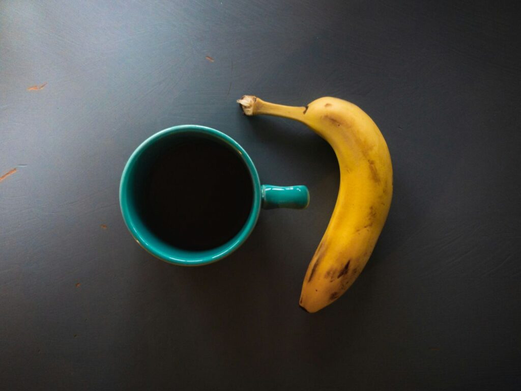 banana al fianco di tazza di caffè