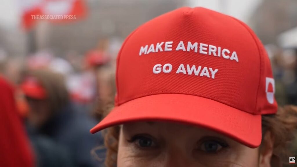 Un cappellino rosso con la scritta "Make America Go Away" sul capo di una manifestante danese