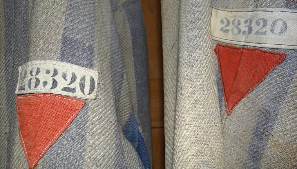 I distintivi rossi dei prigionieri politici sull'uniforme di un detenuto di Dachau