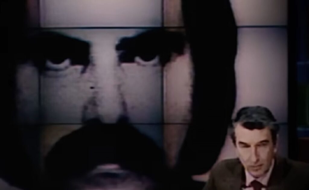 Tony Chichiarelli alle spalle di Corrado Augias durante una trasmissione TV