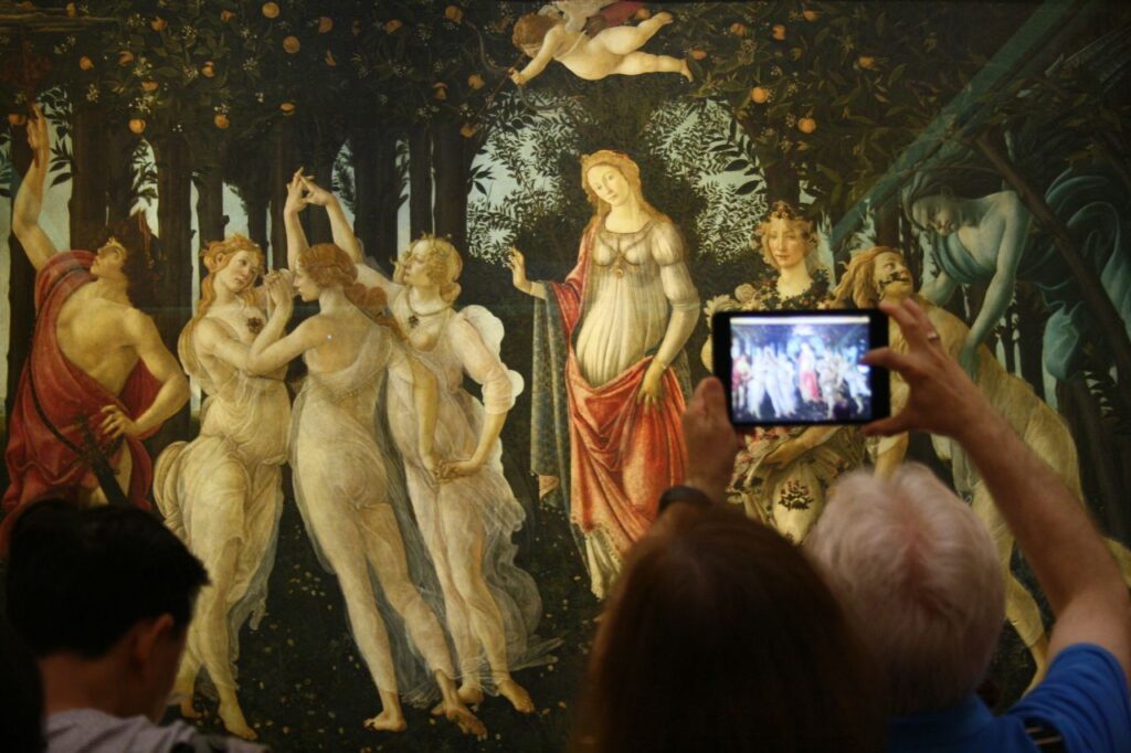 persona fotografa La Primavera del Botticelli agli Uffizi di Firenze