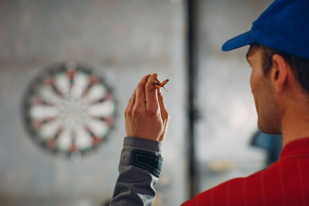 uomo che gioca a freccette
