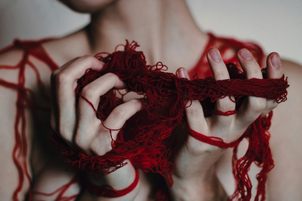 Esiste davvero il filo rosso che unisce le anime gemelle? La verità su questa antica credenza donna tiene in mano fili rossi