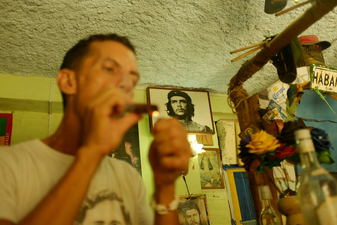 Un uomo si accende un sigaro a L'Avana