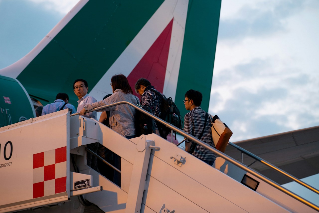 Alcuni passeggeri si imbarcano su un volo Alitalia