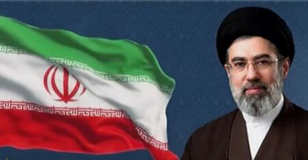 Mojitaba Khamenei vicino alla bandiera iraniana