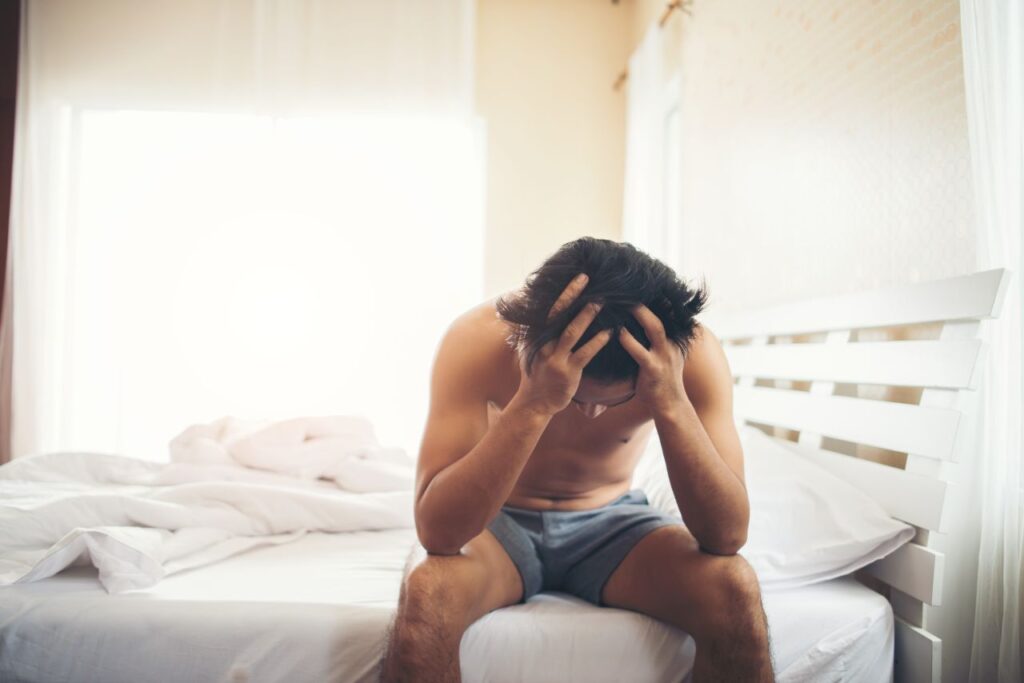 Uomo preoccupato seduto sul letto